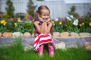 Beautiful girl sitting in her garden and laughting photo