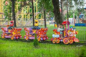 Two little fashion lovely sisters ride on the children's train photo