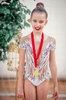 hermosa pequeña gimnasta entrenando en la alfombra y lista para las competiciones foto