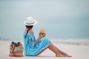 Young woman drinking coconut milk during tropical vacation photo