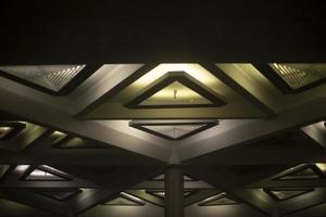 Light of lamps on ceiling. Architecture details. Triangles in building. photo