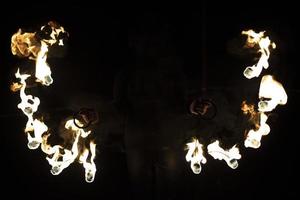 espectáculo de fuego en la oscuridad. dos ventiladores de acero con llamas calientes. foto