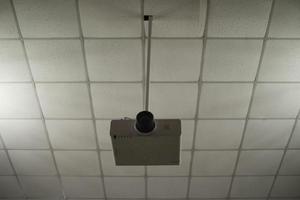 Movie projector hangs from ceiling. Projector for video broadcasting. photo