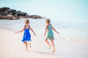 Little happy kids have a lot of fun at tropical beach playing together photo