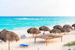 Idyllic tropical beach with white sand, turquoise ocean water and big palm trees photo