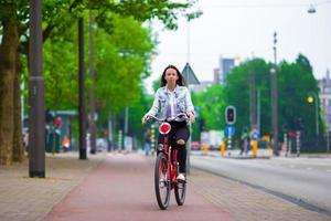 joven mujer feliz en bicicleta en ciudad europea foto