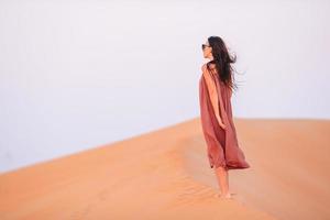 Girl among dunes in desert in United Arab Emirates photo