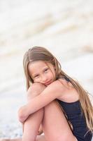 Adorable little girl have fun at tropical beach during vacation photo