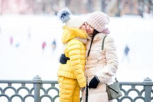 Little adorable girl with her mother on ice-rink photo