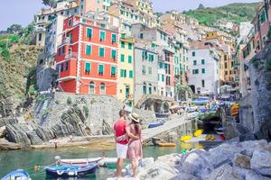 Tourists looking at scenic view of Riomaggiore, Cinque Terre, Liguria, Italy photo