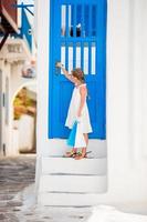 Beautiful girl at street of typical greek traditional village on Mykonos photo