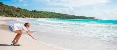 Adorable little girl on white tropial beach photo