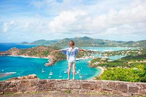 Little adorable kid with beautiful famous view. View of English Harbor from Shirley Heights, Antigua, paradise bay at tropical island in the Caribbean Sea photo