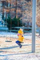 Adorable little girls swings on a swing in Central Park at New York City photo