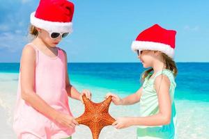 adorables niñas en vacaciones navideñas en la playa. foto