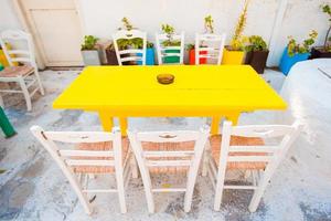 Empty openair cafe with colorful tables at greek old village photo