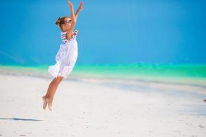 Adorable little girl at beach during summer vacation photo