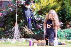 Happy little witch outdoors on Halloween. Trick or treat. photo