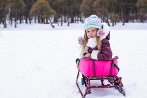 Adorable little girl having fun during winter vacation photo