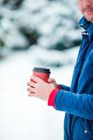 café de primer plano para ir en manos masculinas en el día de invierno congelado al aire libre foto