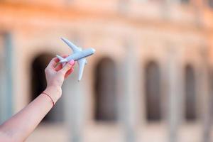 Closeup toy airplane on Colosseum background. Italian european vacation in Rome. Concept of imagination. photo