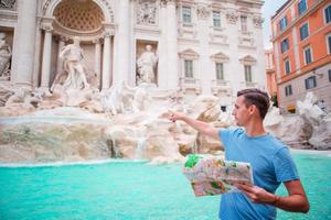 Happy man looking at touristic citymap near Trevi Fountain, Rome, Italy. photo
