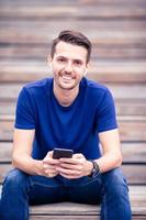 Man is reading text message on mobile phone while walking in the park photo