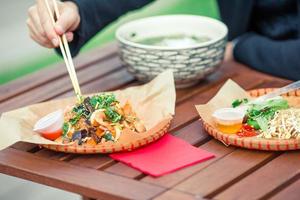 Asian rice noodles with vegetables and sause close-up on the table photo