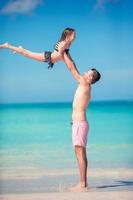 Family of father and sporty little girl having fun on the beach photo