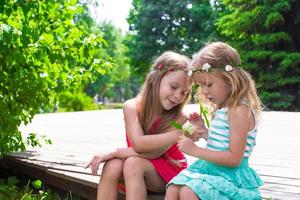 Happy adorable little girls enjoying warm summer day photo