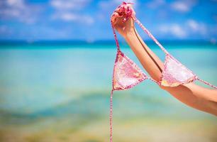 Pink swimsuit on background of turquoise tropical sea photo