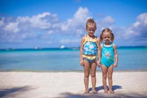 Two little sisters in nice swimsuits at tropical beach in Philippines photo