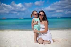 Young beautiful mother and her adorable little daughter at tropical beach photo