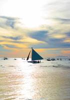 velero en una hermosa puesta de sol colorida foto