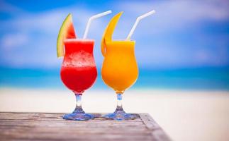 Two cocktails fresh watermelon and mango on background of stunning turquoise sea photo