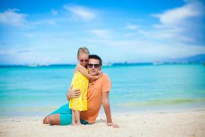 Young father and his adorable little daughter have fun at beach photo