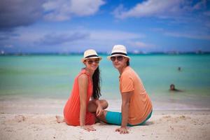 Young couple enjoying each other on a tropical beach and looking at camera photo