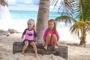 Two little sisters in nice swimsuits have fun at tropical Tulum beach,Mexico photo