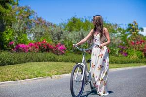 jovencita montando en bicicleta en un resort tropical foto