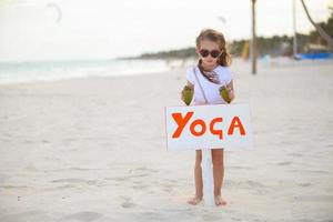 Little cute girl enjoying vacations with two coconut on the beach photo