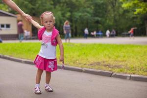 Adorable little girl walking outdoor and having fun in park photo