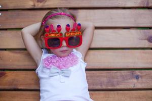 Cute little girl in red Happy Birthday glasses photo