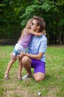 Young father hugging his little adorable daughter outdoors photo