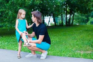 Young father pities his little daughter, who hurt her leg photo