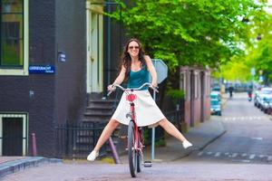 joven mujer feliz en bicicleta en ciudad europea foto