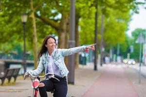 joven mujer feliz en bicicleta en ciudad europea foto