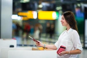 Woman with passports and boarding passes at the front desk at airport photo