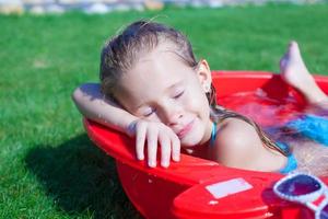 primer plano de una linda niña disfrutando de sus vacaciones en la piscina al aire libre foto