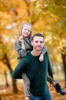 Family of dad and kid on beautiful autumn day in the park photo