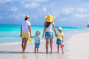 Happy family of four on caribbean holiday vacation photo